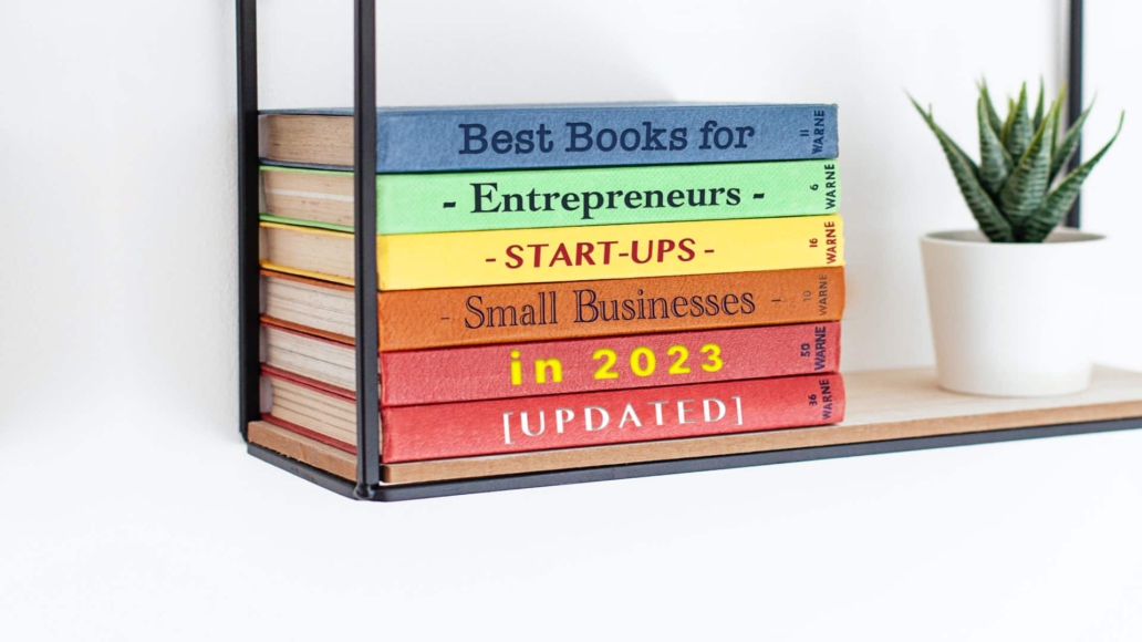 Image of bookshelf with plant and selection of Best Business Books To Read in 2023