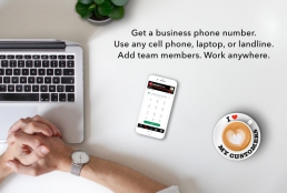 Desk, plant, laptop, mobile phone displaying cloud-based phone system sofware app